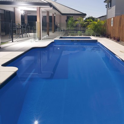 Fibreglass pool beside an alfresco area with glass fencing